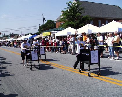 3 Librarians rolling book carts down Main Street